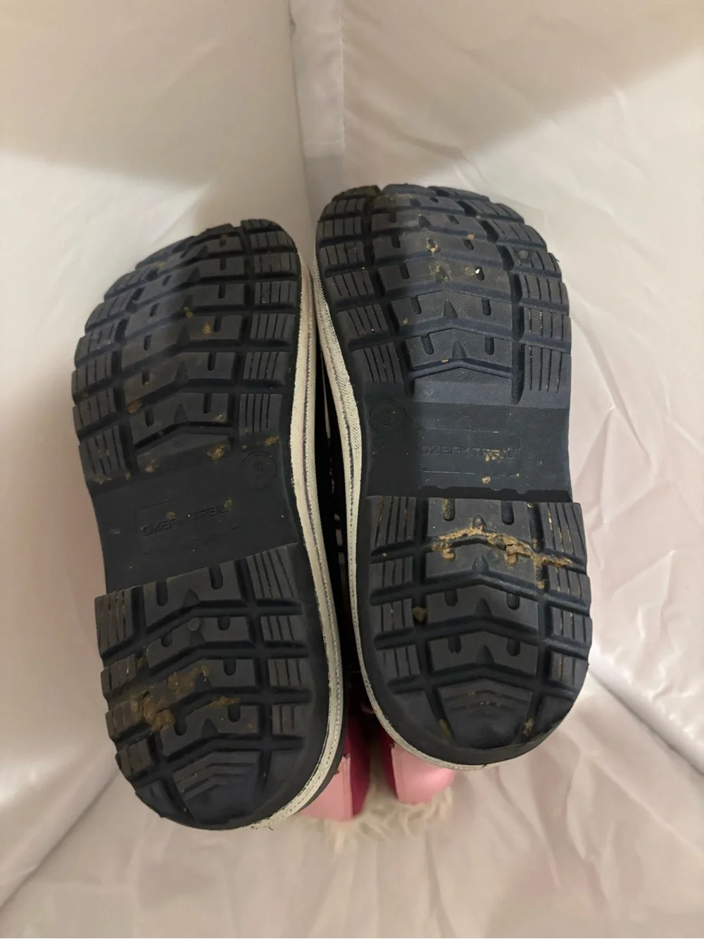 The image shows the black rubber lug outsole of an Ozark Trail kids' winter boot